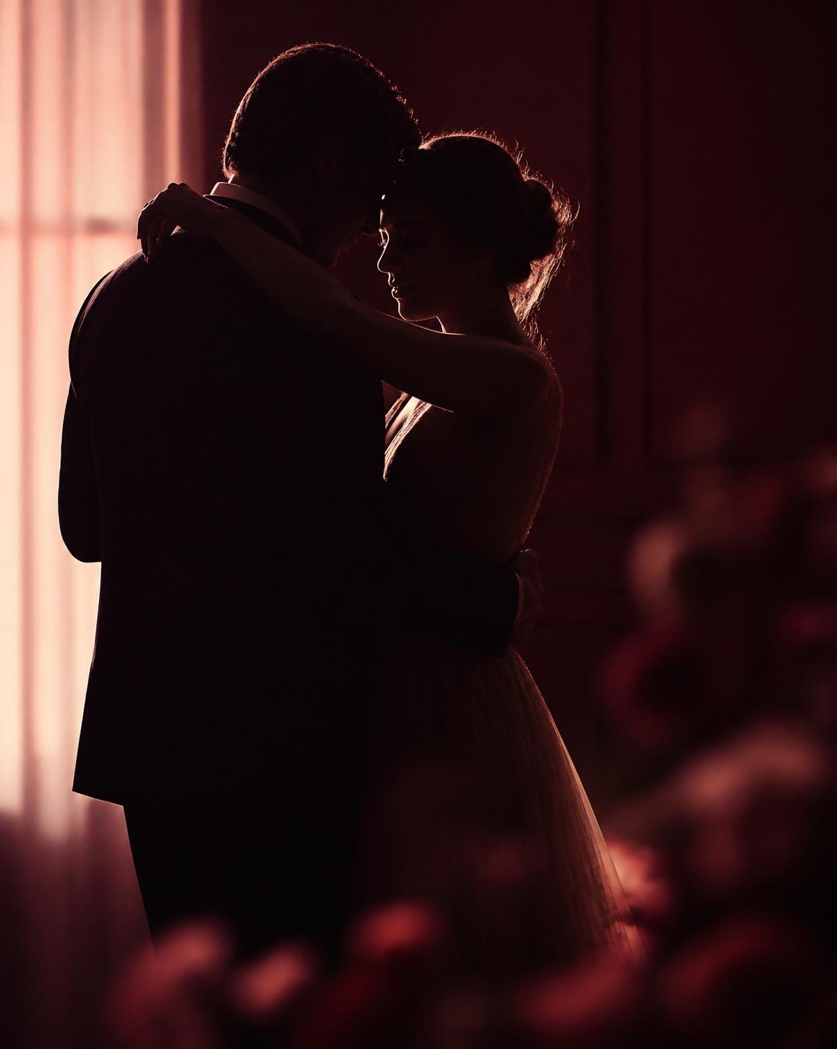 Couple embracing in soft window light